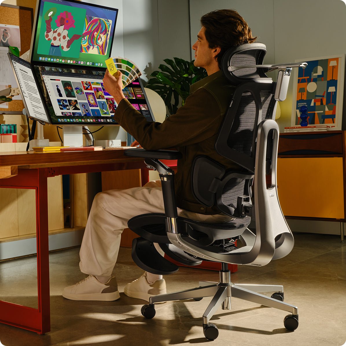 Person sitting at a desk with multiple computer monitors in a home office setting~scene
