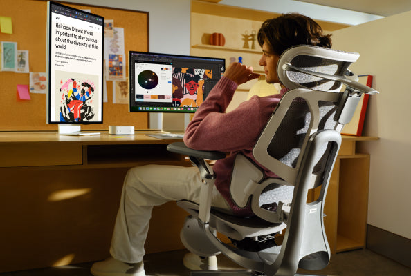 Person seated in an ergonomic chair at a home desk