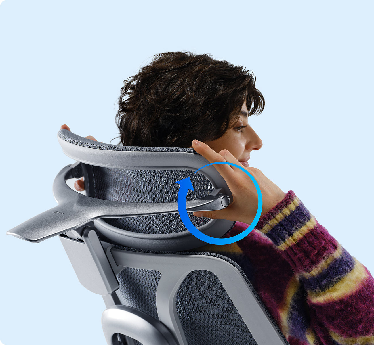 Person adjusting the rotating headrest on a gray mesh HBADA ergonomic office chair
