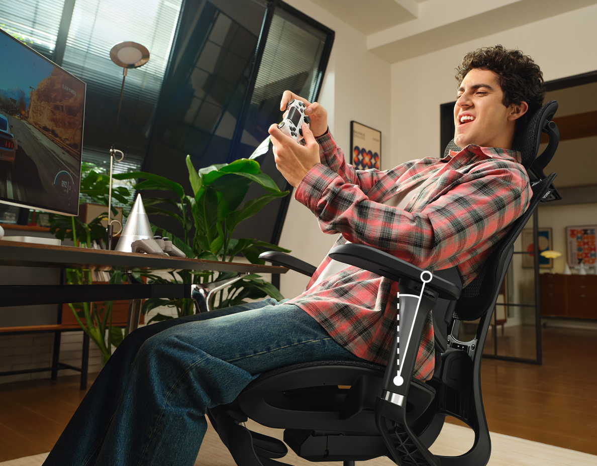 Person using an ergonomic chair in a home workspace
