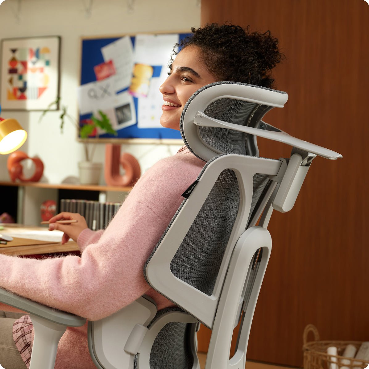 a woman sitting in a modern office chair in a home office setting ~scene