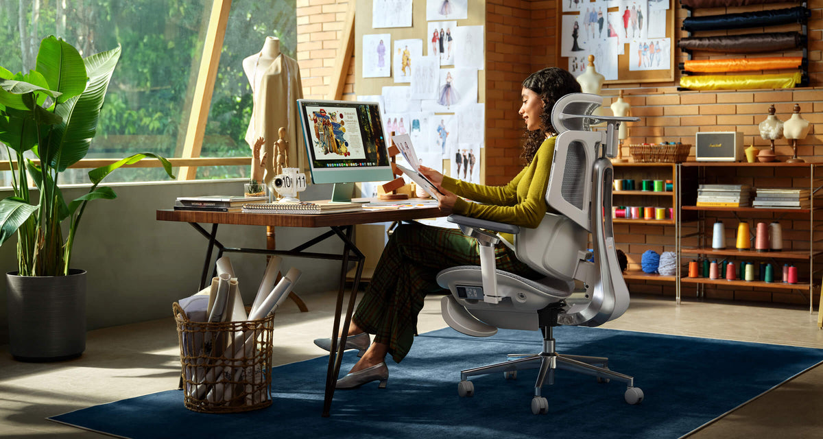 Woman working in an ergonomic office chair in a fashion design studio